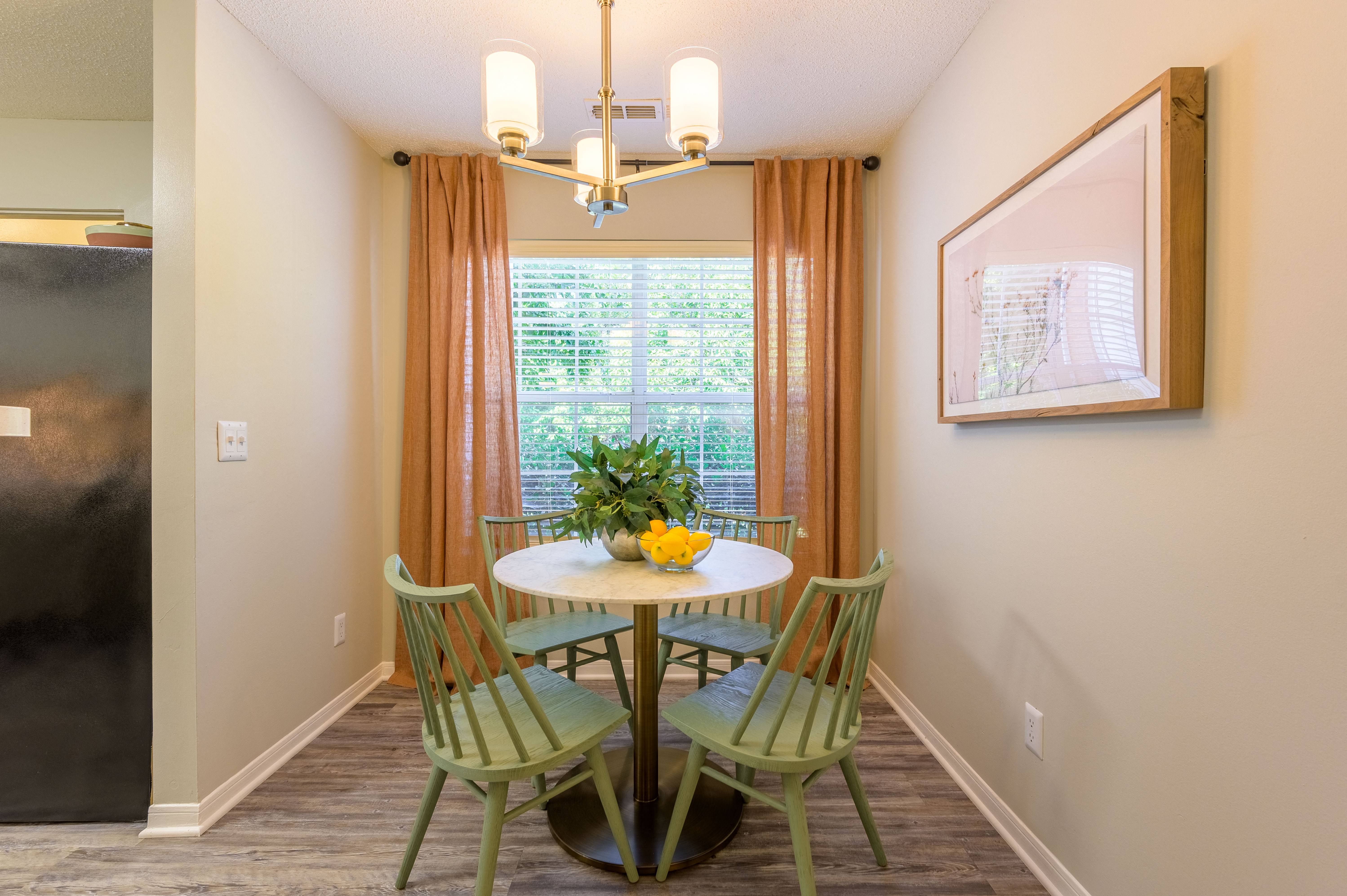 a dining room with a table and chairs and a window